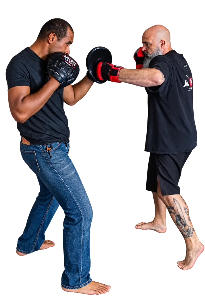 Coach Jeff striking a focus mitt held by a training partner